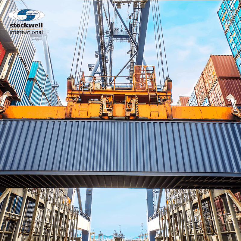 retail freight forwarding. Image of a shipping container being picked up by a crane